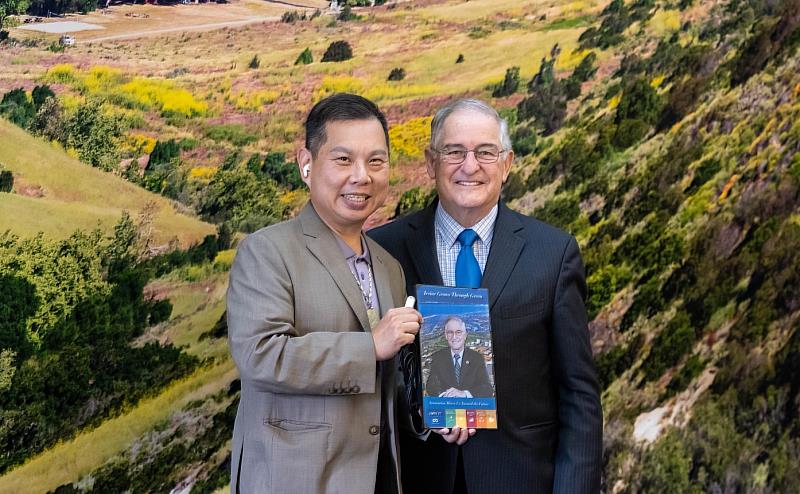 薛煒立創辦人(左)致贈美國加州爾灣市市長 Larry Agran(右)客製化彩繪光電板,並就城市永續、建築能源及公共場域應用進行交流,展現彩繪立面光電結合再生能源、建築美學與城市發展的應用潛力。(圖/在一起永續科技提供)