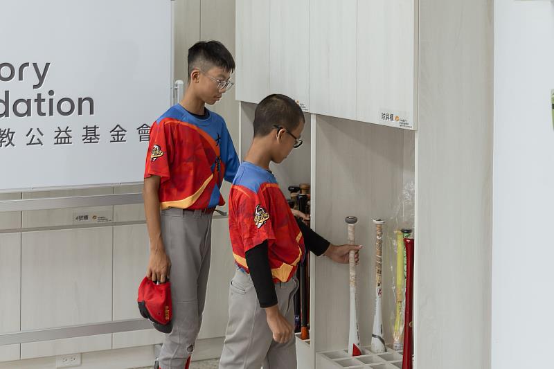 少棒隊球員迫不及待,將球棒放入他們的客製化裝備櫃中,遠雄基金會透過規畫收納櫃,增加球隊教室運用空間。