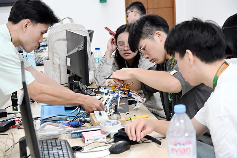 三校學生共同進行四足機器人的機構組裝與線路配置。