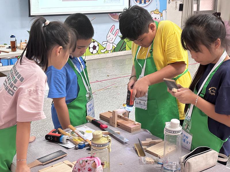 學童們主動協助彼此克服工具操作與組裝困難。