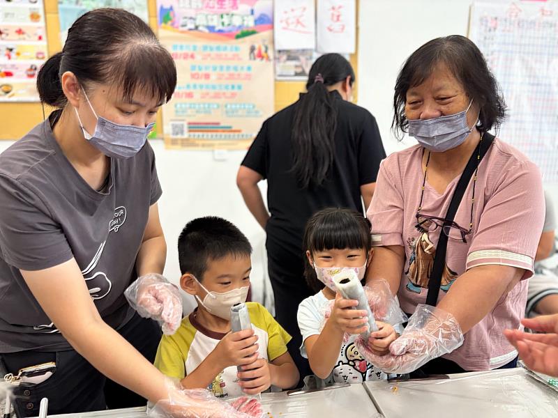 阿嬤陪著孩子們開心展示完成的粄條壽司,現場充滿溫馨歡笑。