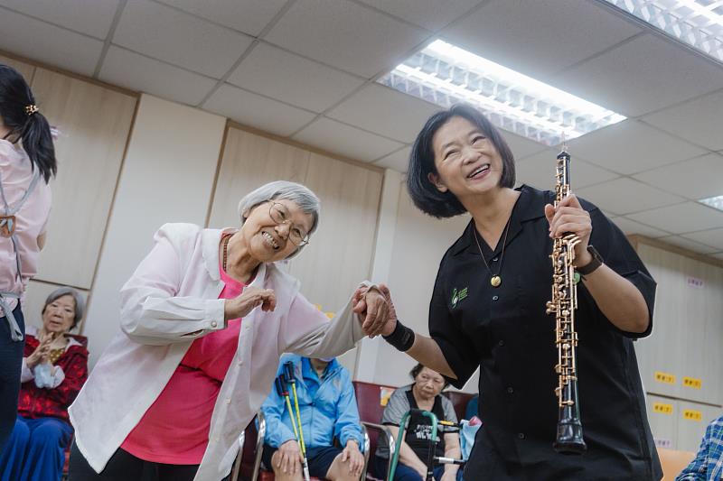 長者欣賞長榮交響樂團帶來的義演演出，並與團員在節奏互動中感受音樂樂趣。