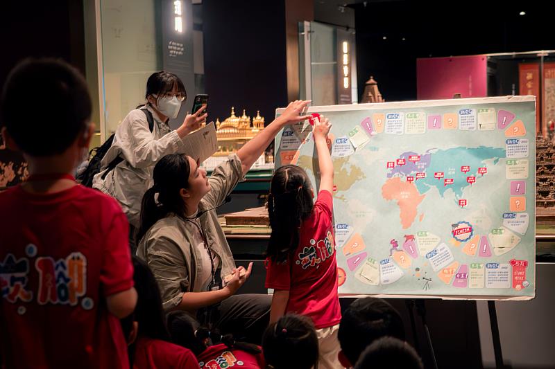 圖3,崁腳國小學童化身「世界旅行家」,分組挑戰趣味大富翁遊戲,從互動問答中認識世界宗教文化。(圖由世界宗教博物館提供)