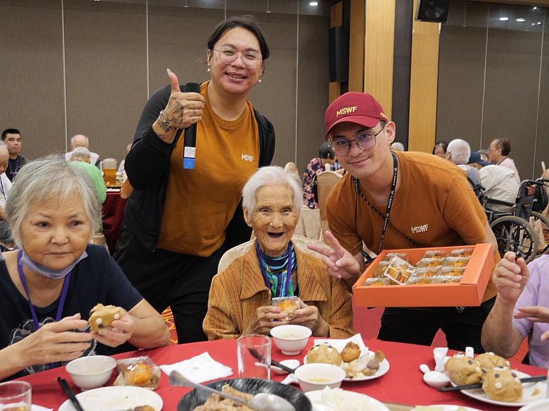 門諾基金會緊急守護連線個案 96 歲林阿嬤(中)喜領月餅,與同仁共祝中秋節快樂。