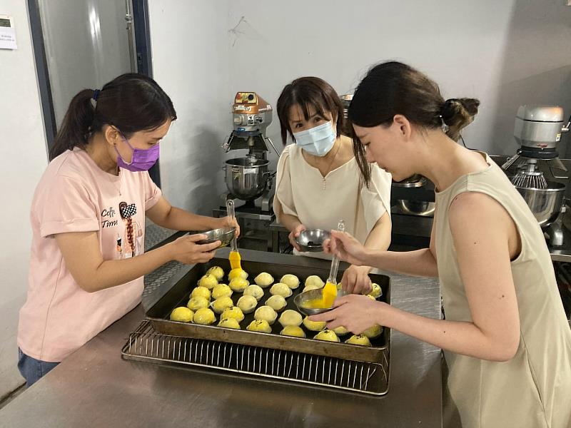 同仁在蛋黃酥表面刷上蛋黃液。