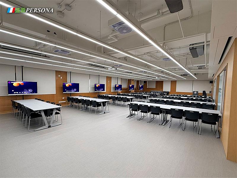 多台55吋觸控螢幕依教室格局分散設置，搭配分組桌椅，支援課堂講授、分組討論與互動教學。
