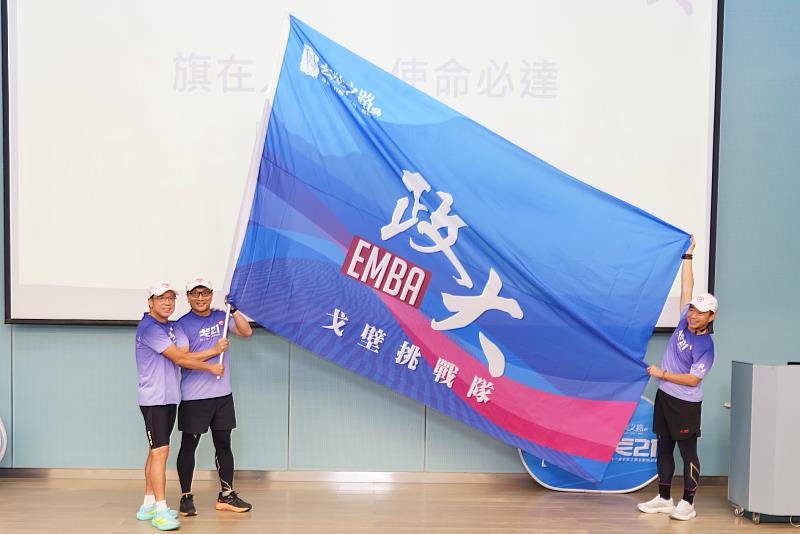 黃家齊院長親自授旗，由戈21會長黃士元代表團隊接下隊旗，象徵戈21正式迎接戈壁挑戰。（政大戈21提供照片）