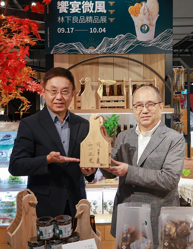 農業部林業及自然保育署署長林華慶(左)與微風超市總經理西川正史(右)共同在國產柳杉啤酒提籃簽署,象徵林下良品與微風超市合作推廣森林系質感產品。