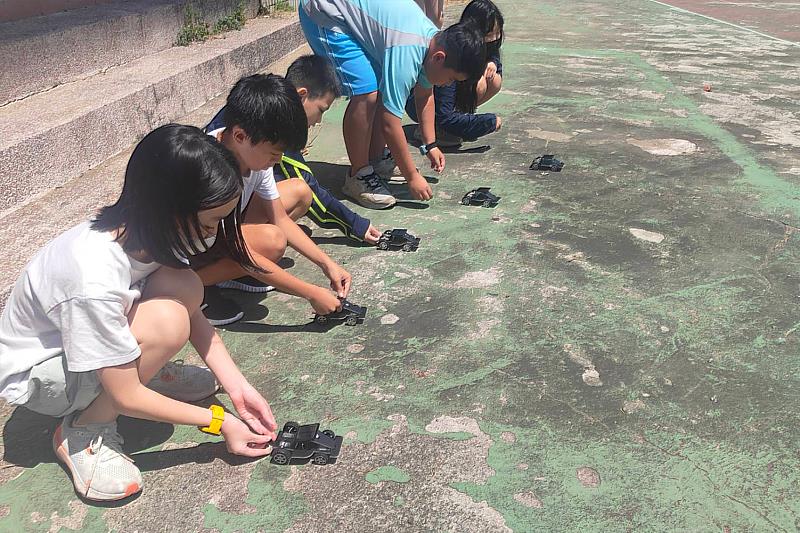維新國小學童於戶外測試親手組裝的太陽能小車,觀察太陽光能轉換為電能的過程。