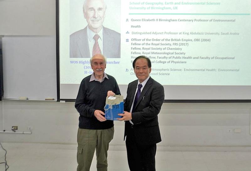 中國醫藥大學公共衛生學院院長何文照教授致贈英國伯明罕大學教授、英國皇家學會院士Roy M. Harrison紀念品。