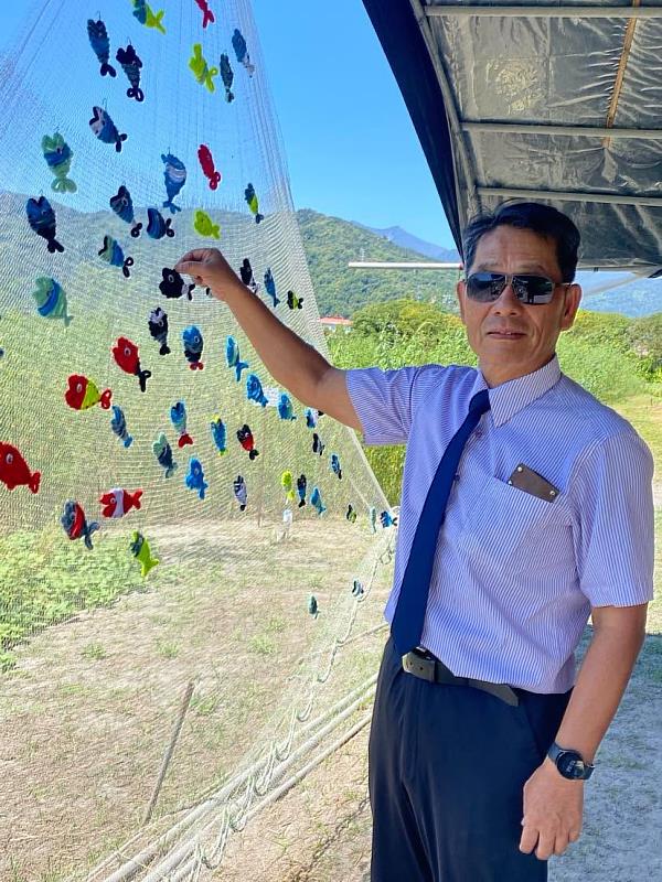 徐輝明校長參與展覽互動,掛上象徵「逆流而上的希望」的小魚,為邦查農場災後新生留下祝福。
