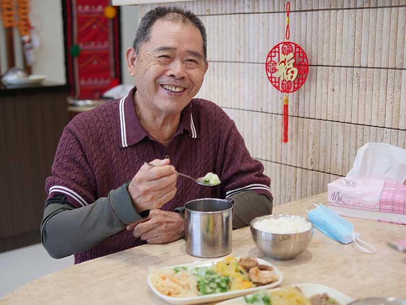 接受玉里「甜心食堂」服務的80歲邱伯伯開心用餐，盛讚餐食營養美味、軟嫩好吞嚥，現已成為食堂的忠實粉絲。