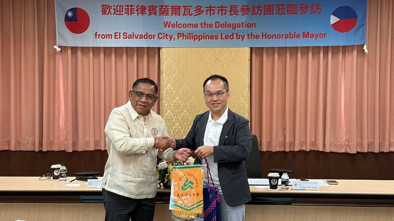 崑山科大陳淏煬國際長(右)致贈禮品予菲律賓薩爾瓦多市市長 Hon. Edgar S. Lignes(左)。
