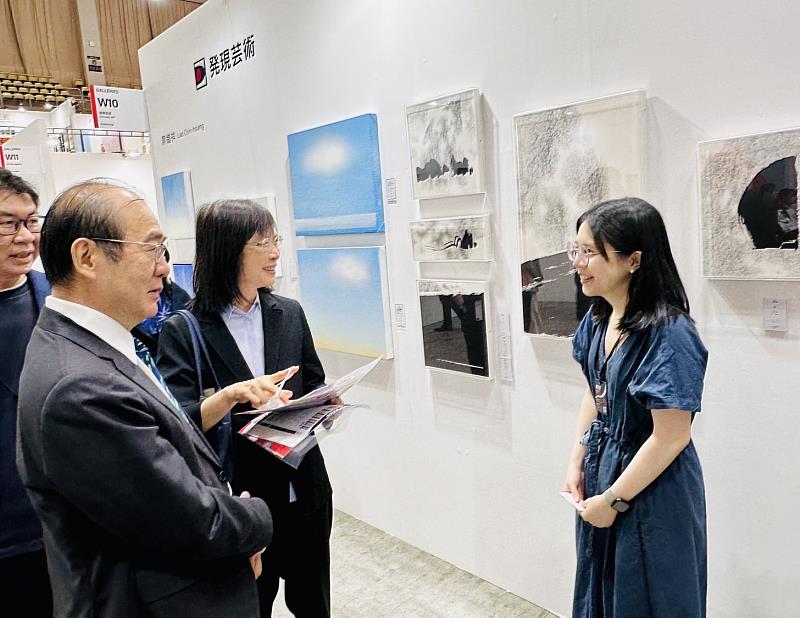 青年藝術家(右)向陳處長夫(左)婦介紹參展作品。