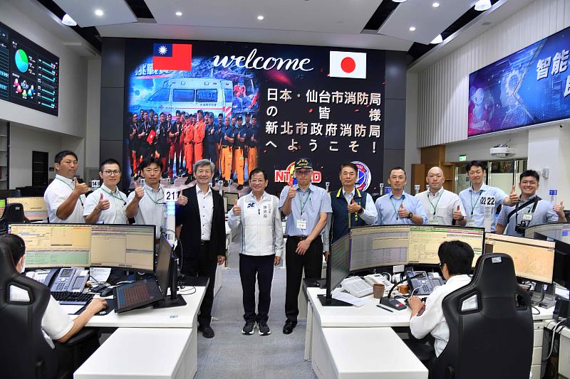 新北市政府消防局與日本仙台市消防局代表隊於救災救護指揮中心合影留念。照片左4為內政部消防署組長李明憲,左5為新北市政府消防局局長陳崇岳,左6為仙台市消防局警防課長近藤存一。