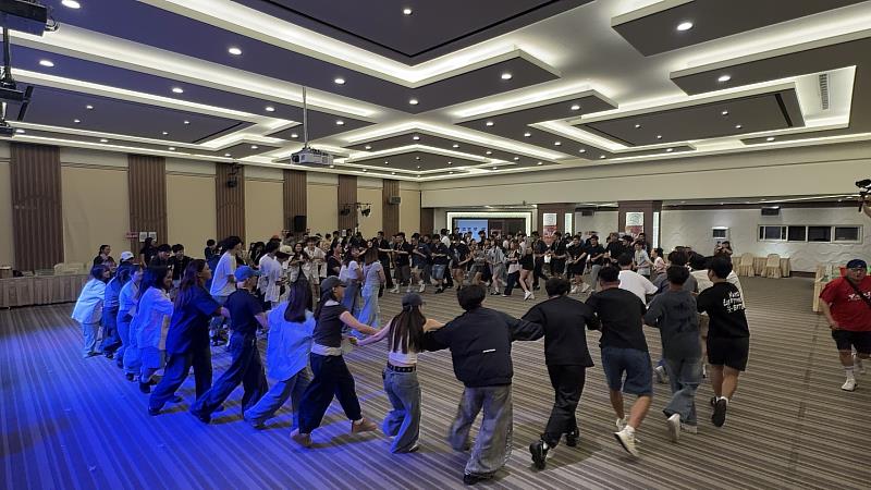 學生牽手圍成大圈,參與聯合迎新的團體互動活動。
