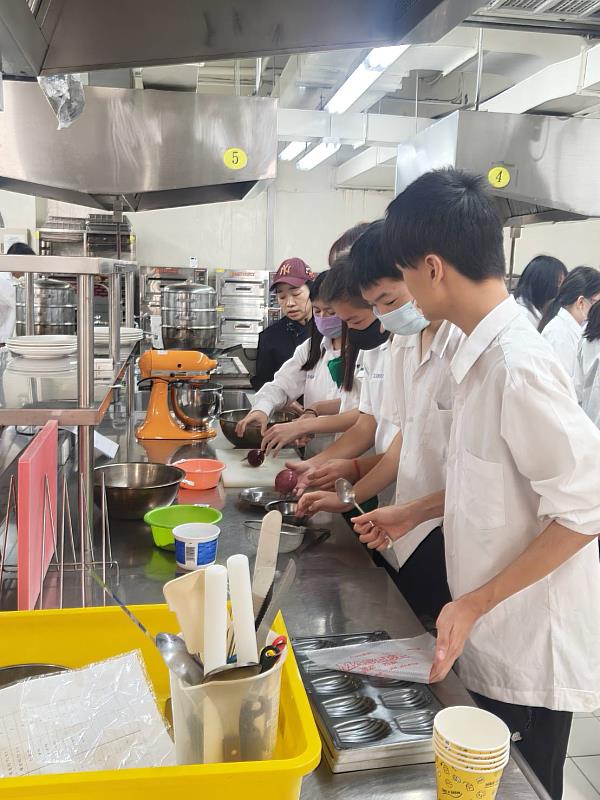 元培老師教導君毅高中學生學習烘焙食品的技巧。
