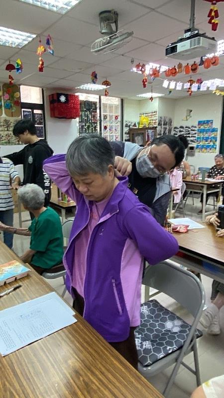 元培高齡系學生為社區長輩做上肢柔軟度測量。