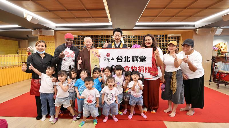 5、蔣市長頒贈愛心物資給台灣關愛基金會蘇素倫主任和10多位不同國籍的可愛孩子們。(靈鷲山佛教教團提供)