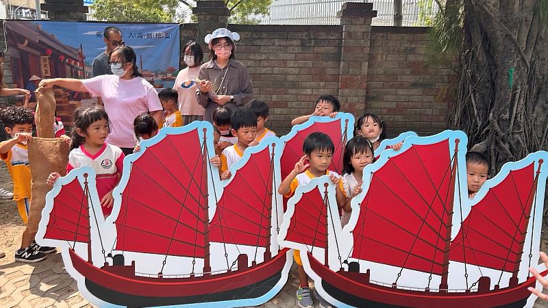 幼兒合力抬著大型貨船模型移動,模擬昔日貨船駛入臺南運河入關檢查情景。