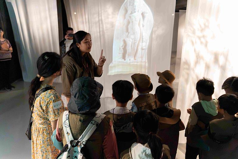孩子探索《光在萬物》特展,穿越「創世之光」的布幔。(圖由世界宗教博物館提供)