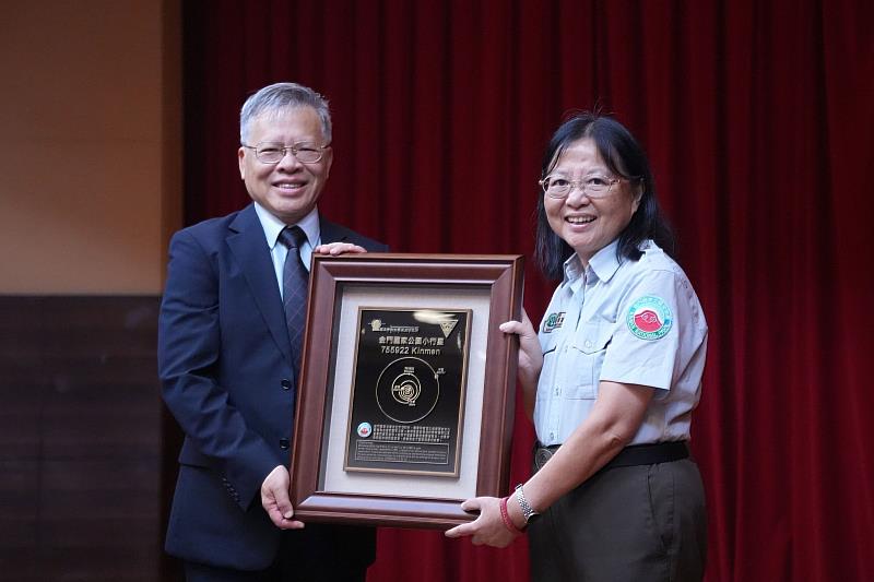 中央大學蕭述三校長（左）頒贈「Kinmen」小行星銘版給金門國家公園黃子娟處長（右）。
