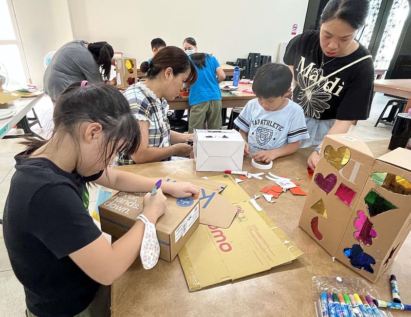 家長陪伴孩子們，運用廢棄紙箱製作玩具。