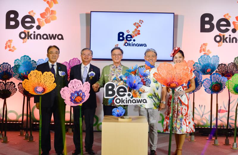 日本台灣交流協會代表沼田幹夫(左一)、外交部主任秘書蔡明耀(左二)、沖繩縣知事翁長雄志(中)、沖繩觀光會議局會長平良朝敬(右二)，與沖繩小姐嘉數晴花(右一)一同宣告「沖繩祭 遇見沖繩」活動正式開始。 
