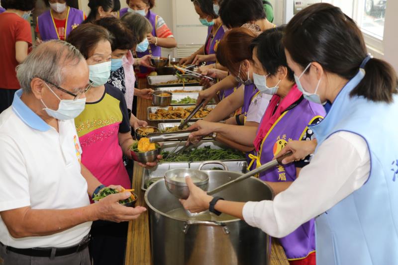 畫眉鳥晚香玉協會志工團幫長輩打餐  洪佳君議員也幫忙舀湯。