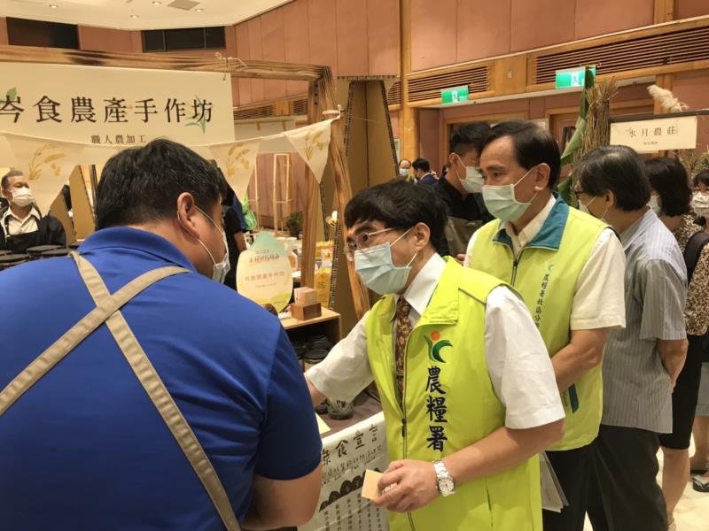 農糧署主秘陳啓榮(左二)，在展場中與農民互動交流。