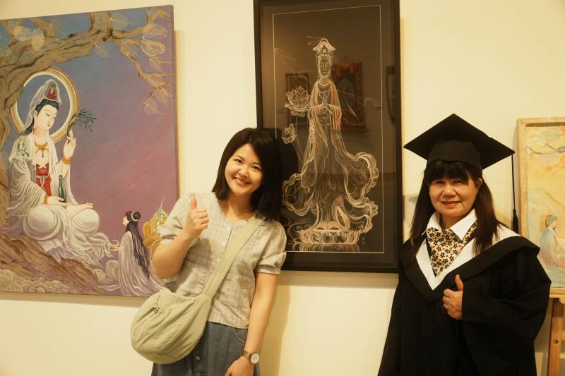 華梵大學佛藝系巫春梅同學（右）與女兒在作品〈幻象觀音〉、〈點石成金〉前合影。