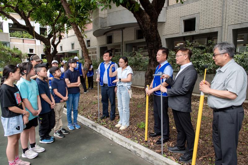 中華電信攜手臺北市政府教育局至臺北啟聰學校校園量測樹木碳匯，中華電信董事長簡志誠(右3)、總經理林榮賜(右5)、台北市政府教育局副局長鄧進權(右2)、與手語老師陳昭妤(右4)，向啟聰學校學生介紹量測樹木碳匯的方法。