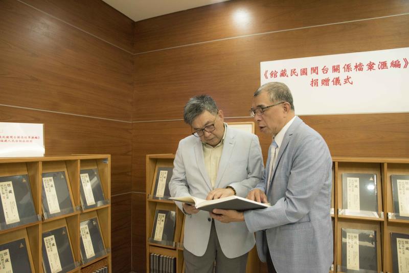 華梵大學李天任校長（左）與出版協會楊蓮福理事長仔細閱讀贈書內容。
