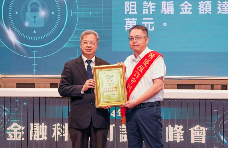 第一銀行阻詐表現獲金管會表揚，由行政院秘書長龔明鑫（左）頒獎，第一銀行大溪分行副理李富傳（右）代表受獎。