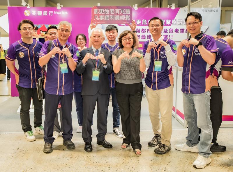 兆豐銀行力挺都更危老，董事長董瑞斌(前排左二)率隊參加第七屆危老都更博覽會，與力銘建設董事長郭淑珍(前排右三)及銀行同仁合影。