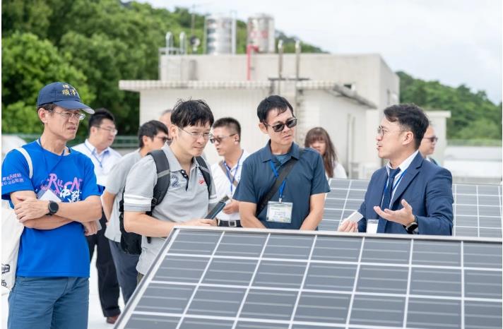 明志科大電機系羅慶權老師在電機工程館頂樓介紹太陽光電系統配置與微電網整合經驗分享。
