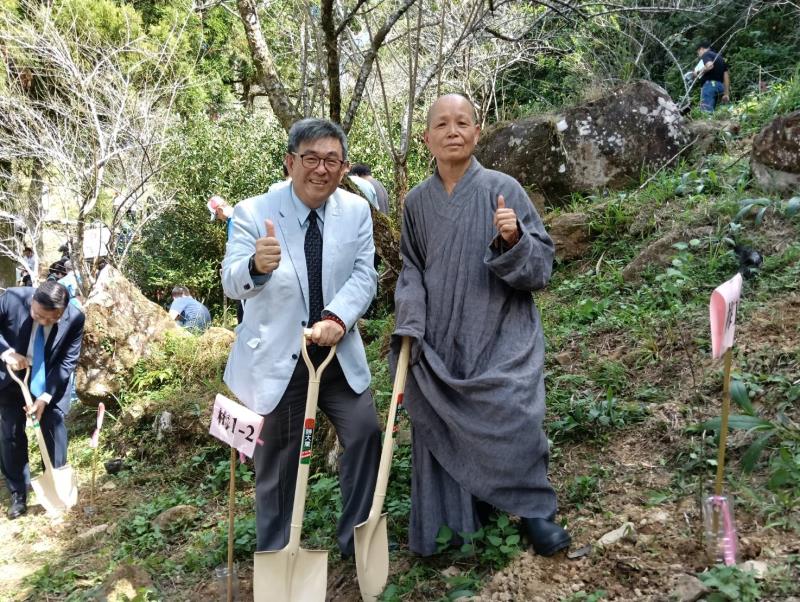 華梵大學董事長悟觀法師（右）與李天任校長開心種下自己認養的二代梅樹。