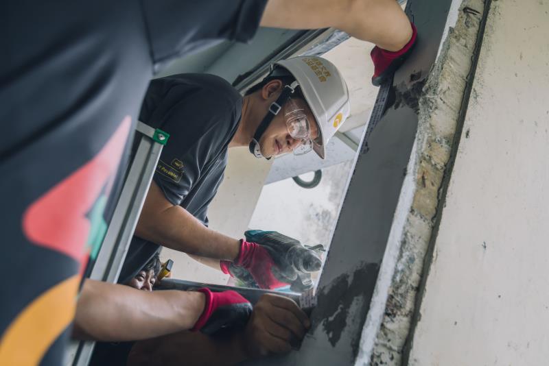 遠雄志工將損壞的氣窗鎖上新鋁架，後續將再安裝矽酸鈣板，將牆面缺口補上.