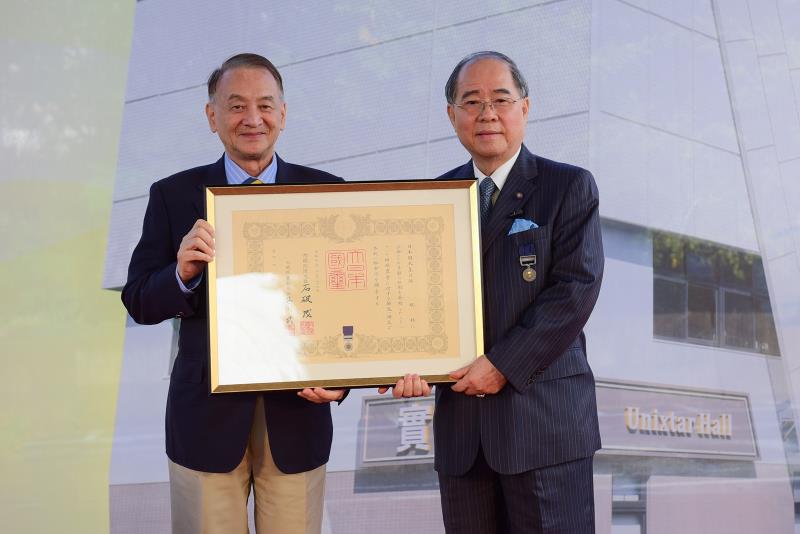 中原大學董事長張光正（左）代頒日本天皇褒狀予邱秋林校友（右），表彰其對教育及社會公益的卓越貢獻。
