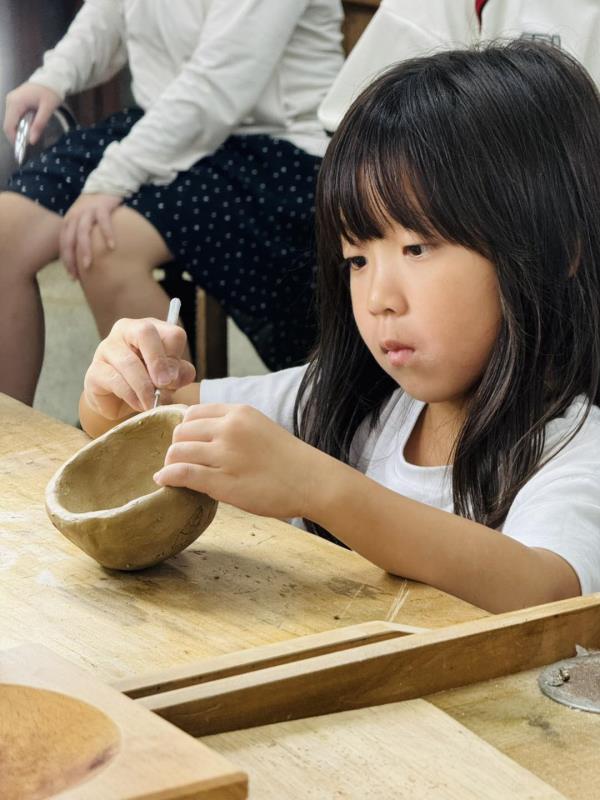 原來學苑的學童在華梵大學的陶藝課上手作捏陶。
