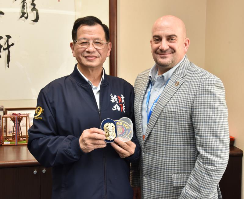 新北市消防局長陳崇岳與美國 Kevin Joles 科長互贈紀念品。