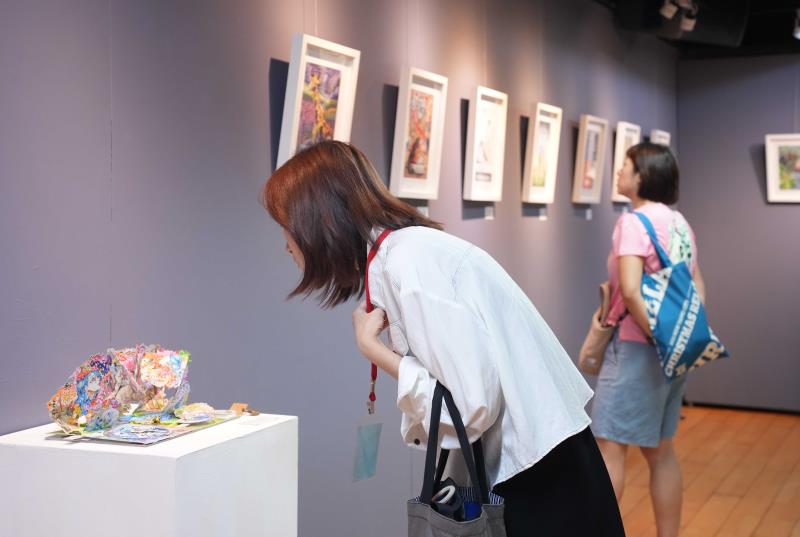 參觀者仔細欣賞得獎作品。