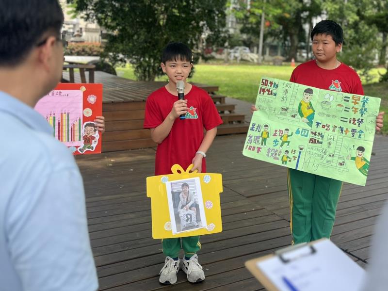 桃園內柵國小的孩子拿著自己減重前的照片，展示自己的減重規畫及成果。