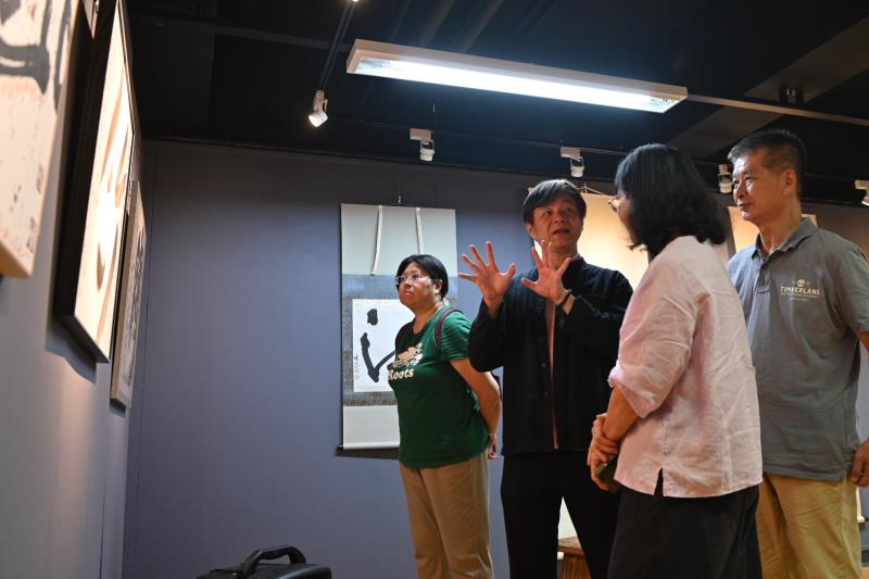 策展人華梵大學人文與藝術學院黃智陽院長（左二）向參觀者導覽作品。