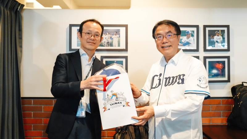 臺南市長黃偉哲（右）致贈臺南特色伴手禮予埼玉西武獅球團董事山崎賢（左），盼持續深化臺日棒球與觀光交流。