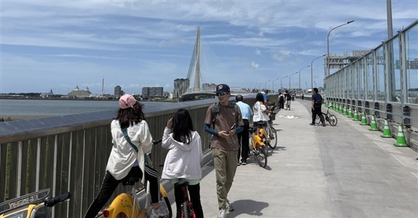 Danjiang Bridge attracts crowds on its first weekend; drivers say the view makes traffic bearable.